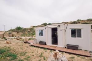 a small white house with a wooden deck at Erato's Cottage in Plaka