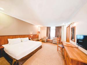 a hotel room with a bed and a flat screen tv at StarLodge in Kampong Jerudong