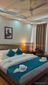 a bedroom with a large bed with blue pillows at the town ville manali in Manāli