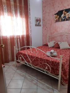 a bedroom with a bed with a red comforter at Casa Marina Maltese via ucca marina SANTA MARIA DEL FOCALLO ISPICA in Santa Maria Del Focallo