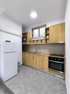 a kitchen with wooden cabinets and a white refrigerator at KAFUL APARTMENTS in Qeparo +31 photos