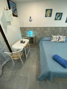 巴勒莫Il sole siciliano的一间卧室配有一张蓝色的床和一张桌子 更多16张照片