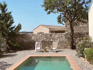una piscina con 2 sillas y una pared de piedra en Casa Les Germanes, en Gramuntell