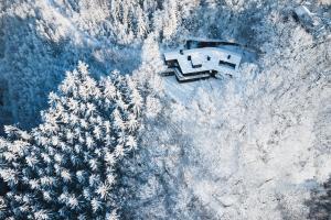 an aerial view of a house in the snow next to trees at L'Écrin de la Warche in Malmedy