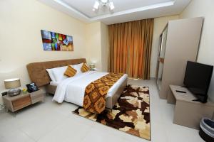 1 dormitorio con 1 cama grande y TV en Al Mansour Park Inn Hotel&Apartment, en Doha