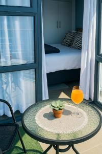 een tafel met een glas sinaasappelsap en een plant bij Charming apartment With Private Balcony in Johannesburg