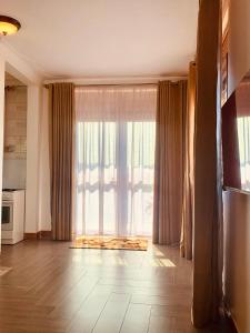 a living room with a large window with curtains at Kampala Studio with Lake Breeze in Kampala