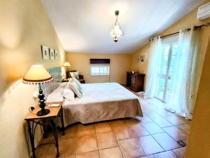 a bedroom with a bed and a lamp on a table at Casa Lo Pinto Private Pool Villa South of El Torcal -UNESCO- in La Joya +50 photos