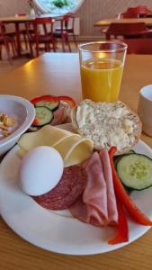 a plate of food with eggs and vegetables and a glass of orange juice at Kuttainen Lodge in Karesuando