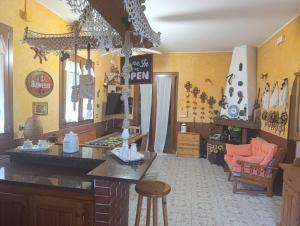 a kitchen with yellow walls and a table with a sign at Villa Aurora in Ognina