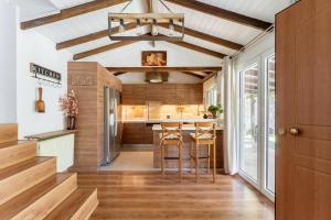 a kitchen with wooden ceilings and a bar with stools at Rustic Garden Cabin in Vari