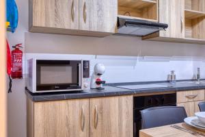a kitchen with a microwave and a stove top oven at New! Modern Studio in central Malta by SF Homes in Msida