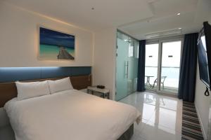 Postel nebo postele na pokoji v ubytování Hamdeok Beach Stay Jeju
