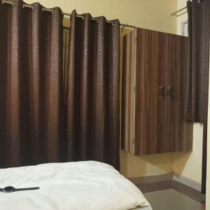 a bedroom with black curtains and a bed in a room at Hotel Shivoham in Mathura