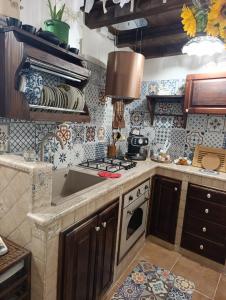 a kitchen with a sink and a stove at Casetta Sarina in Palazzolo Acreide