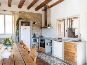 Una cocina con una mesa de madera y un refrigerador. en Casa Les Germanes, en Gramuntell