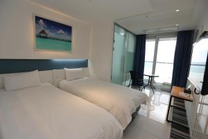 Postel nebo postele na pokoji v ubytování Hamdeok Beach Stay Jeju