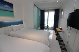 Postel nebo postele na pokoji v ubytování Hamdeok Beach Stay Jeju
