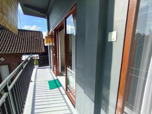 balkon z widokiem na budynek w obiekcie Meme Lan Bape Guest House w mieście Ubud +6 zdjęć