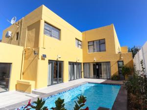 a house with a swimming pool in front of it at Camdale Guesthouse in Cape Town