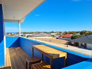 a balcony with a wooden bench and a view of a building at Azure Haven Holiday Home in Port Hughes