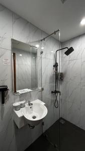 a bathroom with a sink and a mirror at d'primahotel Harmoni Jakarta - Hayam Wuruk in Jakarta +4 photos