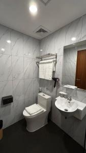a bathroom with a toilet and a sink at d'primahotel Harmoni Jakarta - Hayam Wuruk in Jakarta