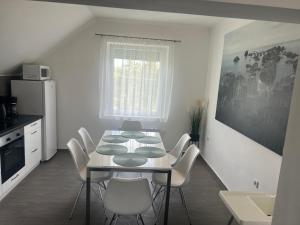 una sala da pranzo con un tavolo e sedie bianche di Olivér 22 Apartman a Fonyód Altre 10 foto
