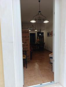 a hallway leading to a dining room with a chandelier at Casetta Sarina in Palazzolo Acreide