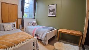 a small bedroom with two beds and a table at Blue Mountains Loft, Tapanui in Glenkenich