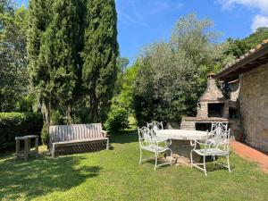 a table and chairs and a bench in a yard at Casa Bianca in Vaiano