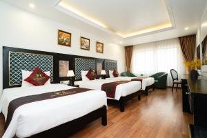 a group of four beds in a hotel room at MT Collection Hotel Ha Long in Ha Long +10 photos