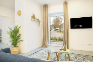 a living room with a blue couch and a large window at Achterdeck in Eckernförde +6 photos