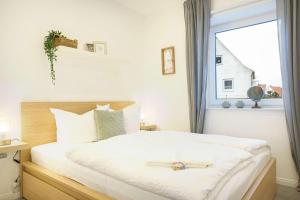 a bedroom with a large white bed with a window at Achterdeck in Eckernförde