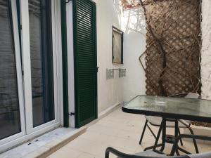 a patio with a table and chairs and a window at Niki Rooms in Tinos +36 photos