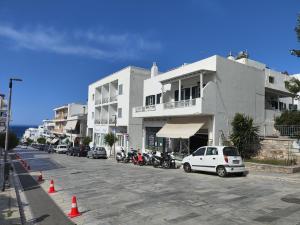 a street with cars parked in front of buildings at Niki Rooms in Tinos
