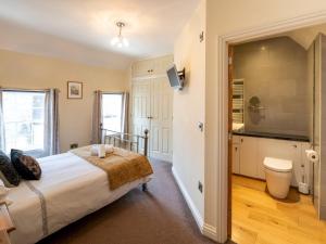 una camera da letto con un letto grande e una televisione di Pass the Keys Bright and cosy flat in the centre of Much Wenlock a Much Wenlock