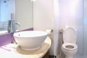 a bathroom with a white toilet and a sink at favehotel Solo Baru in Solo +18 photos