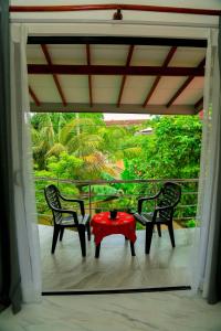 a porch with two chairs and a red table at Sunrise Holiday Apartment in Beruwala +38 photos