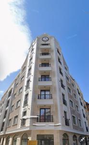 un edificio alto con un reloj encima en Comfort Modern Central Apt, en Haskovo