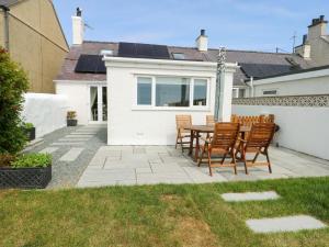 a patio with a table and chairs in a backyard at Ty Bach in Rhosneigr