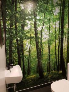a bathroom with a mural of a forest at Modern City Loft, 2BR Split, 2 Levels & Parking in Auckland