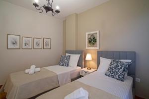 a bedroom with two beds and a lamp at Cozyhome 4 ILISIA in Thessaloniki