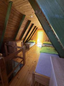 a attic room with two beds and a ladder at Osrodek Nadmorski Osieki in Łazy