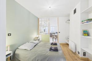 Un dormitorio con una cama grande y una ventana grande en Chic T2 rénové au cœur de Clermont-Ferrand à 2 min de Jaude !, en Clermont-Ferrand