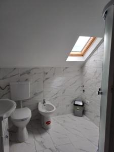 a bathroom with a toilet and a sink and a window at CAZARE EDI in Corbu +51 photos