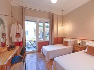 アテネにあるThe Acropolis Windowのベッド2台とバルコニー付きのホテルの部屋