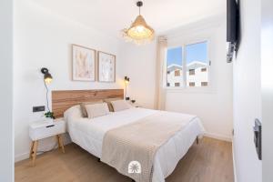 a white bedroom with a large bed and a window at Mediterranean Way - Punta Prima 17 in La Pineda +48 photos
