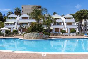 a large swimming pool in front of a building at Mediterranean Way - Punta Prima 17 in La Pineda