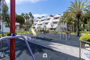 a resort with swings and a playground at Mediterranean Way - Punta Prima 17 in La Pineda
